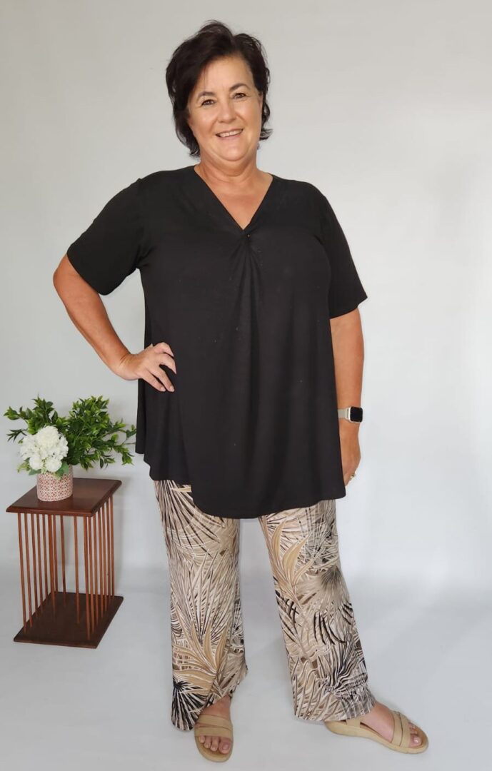 Customer Paula smiling in her J&S Creations Elbie Front Twist Top and matching Paula Bootleg Pants, exemplifying casual elegance