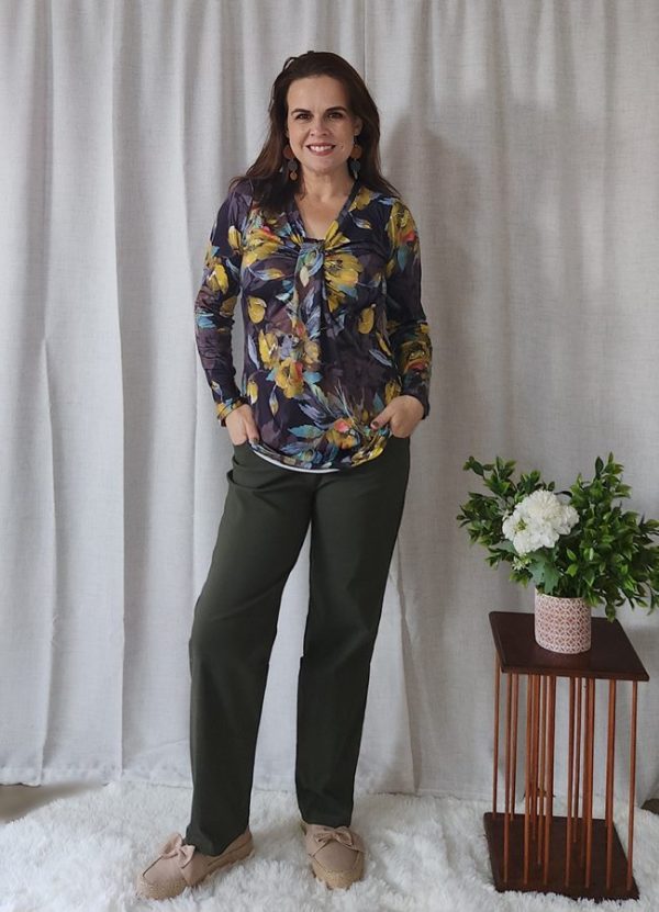 Woman wearing a floral top and olive green Bengaline Relaxed Fit Pants, standing and smiling.