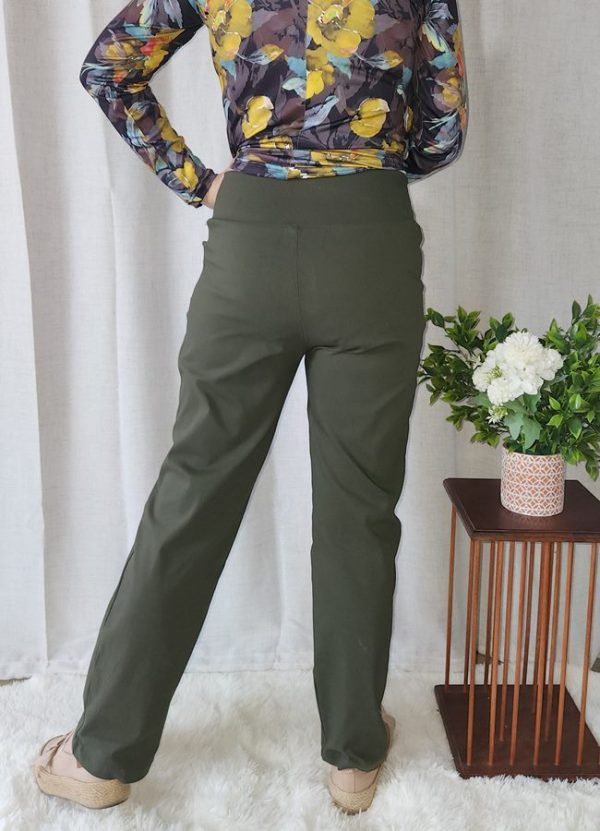 Woman wearing a floral top and olive green Bengaline Relaxed Fit Pants, standing and smiling.