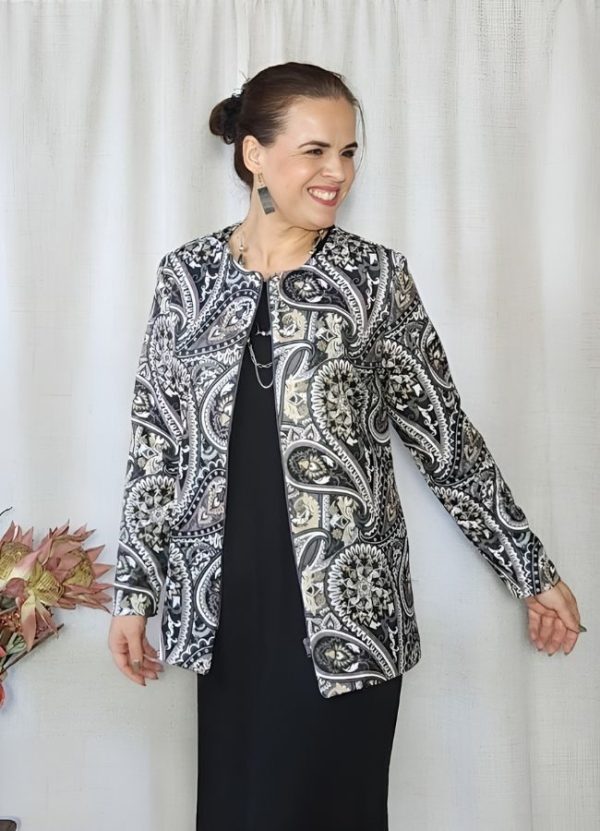 Woman wearing an Emily Custom Style Jacket in a Paisley Mauve printed scuba fabric with a zip closure, smiling and looking to the side.